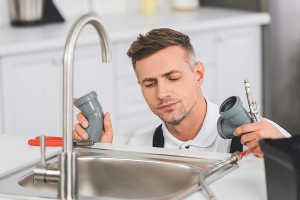 Plumber Fixing Kitchen Faucet